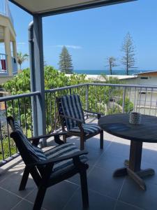 a patio with two chairs and a table on a balcony at Alstan 3 Bedroom Beach House in Coolum Beach