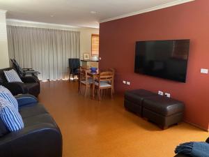 a living room with a couch and a tv and a table at Alstan 3 Bedroom Beach House in Coolum Beach