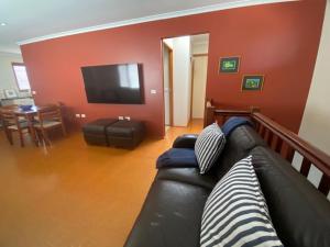 a living room with a black leather couch and a flat screen tv at Alstan 3 Bedroom Beach House in Coolum Beach