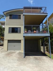 a house with a garage and a balcony at Alstan 3 Bedroom Beach House in Coolum Beach +4 photos