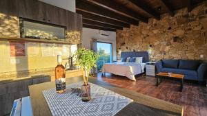a living room with a bed and a table with a bottle of wine at Rincon del Malbec in Ciudad Lujan de Cuyo