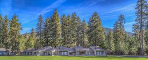 a house in the middle of a field with trees at Lodge Room 006 in Black Butte Ranch