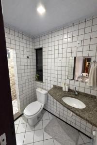 a bathroom with a toilet and a sink and a mirror at Aparthotel holandeses in São Luís +7 photos