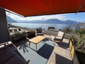a patio with a table and chairs and a view of the water at Cozy studio in Veytaux +10 photos
