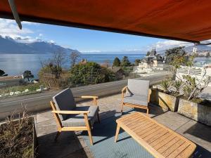 two chairs and a table on a balcony with a view at Cozy studio in Veytaux