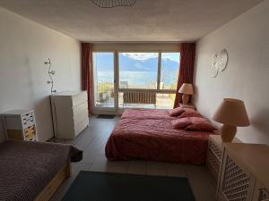 a bedroom with a bed and a view of the ocean at Cozy studio in Veytaux