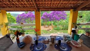 a dining room with a table and a view of trees at Chalé inteiro Canto da Graúna in Ibicoara