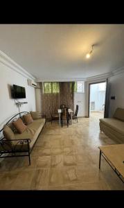 a living room with a couch and a table at Appartement rez de jardin in Hammamet