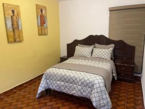 a bedroom with a large bed with a wooden headboard at Sandy's in Morelia