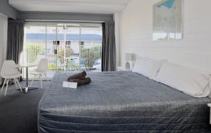 a bedroom with a bed with a teddy bear on it at Dalby Manor Motor Inn in Dalby +74 photos