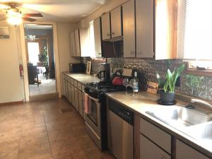a kitchen with a sink and a stove top oven at Wide River Winery Inn in Le Claire