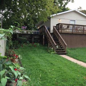 a house with a wooden deck and a yard at Wide River Winery Inn in Le Claire