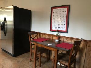 a dining room with a table and a refrigerator at Wide River Winery Inn in Le Claire +5 photos