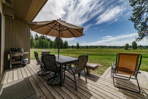 a table and chairs on a deck with an umbrella at Lodge Condo 036 in Black Butte Ranch