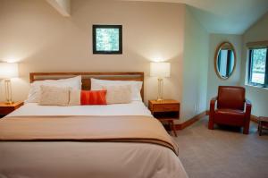 a bedroom with a large bed and a chair at Lodge Condo 014 in Black Butte Ranch