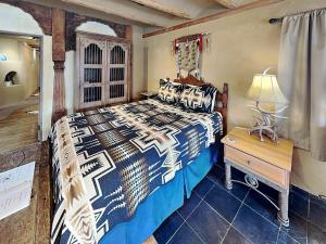 a bedroom with a bed and a table and a lamp at Casita Mariposa in Santa Fe