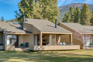 a house with a porch with chairs in the yard at Lodge Room 035 in Black Butte Ranch
