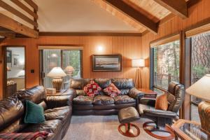 a living room with a leather couch and chairs at Ridge Cabin 022 in Black Butte Ranch