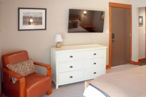 a bedroom with a white dresser and a chair at Lodge Room 016 in Black Butte Ranch