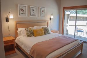 a bedroom with a bed with pillows and a balcony at Lodge Room 016 in Black Butte Ranch