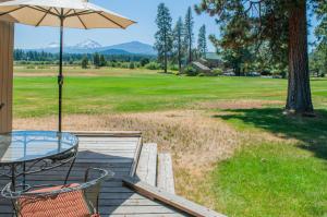 a table and chairs on a deck with an umbrella at Lodge Room 015 in Black Butte Ranch