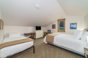 a bedroom with two beds and a table with a desk at Lodge Condo 036 in Black Butte Ranch