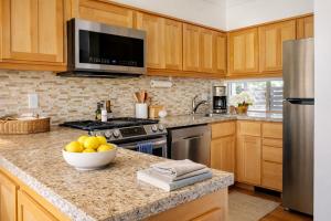 a kitchen with wooden cabinets and a bowl of fruit on a counter at Golf Condo 081 in Black Butte Ranch