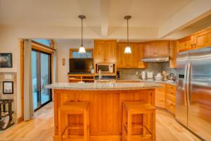 a kitchen with wooden cabinets and a large island with stools at Country House 065 in Black Butte Ranch