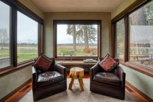 two leather chairs in a room with large windows at Country House 045 in Black Butte Ranch