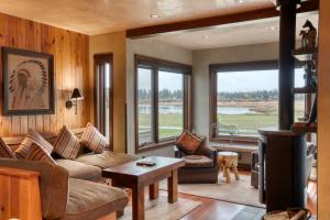 a living room with a couch and a large window at Country House 045 in Black Butte Ranch