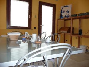 a dining room with a table and two windows at Ametista in Casaleggio Novara