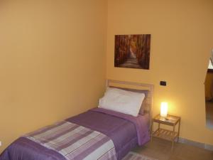 una camera da letto con un letto e un dipinto sul muro di Ametista a Casaleggio Novara