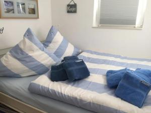 a bed with blue and white pillows on it at Kleine Auszeit in Garding