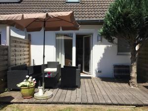 a patio with an umbrella and chairs and a table at Kleine Auszeit in Garding
