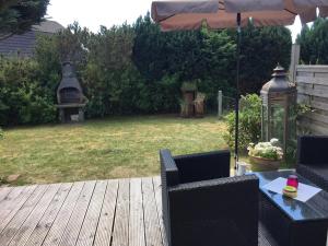 a patio with a table and chairs and an umbrella at Kleine Auszeit in Garding