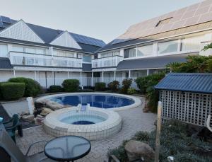 a swimming pool in front of a building at Dalby Manor Motor Inn in Dalby
