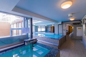 a swimming pool in a building with two swimming pools at Ikebukuro Royal Hotel in Tokyo