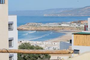 a view of a beach with buildings and the ocean at Eco Bay Surf Camp in Aourir