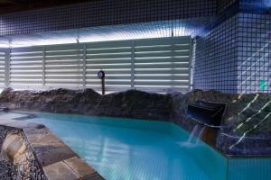 a large swimming pool in a building with a garage at Ikebukuro Royal Hotel in Tokyo +6 photos