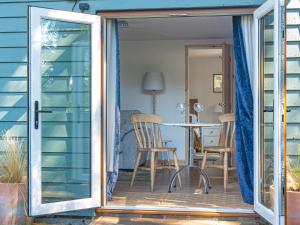 eine offene Tür zu einer Terrasse mit Tisch und Stühlen in der Unterkunft Island Lodge - Uk46767 in Little Baddow