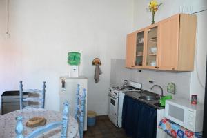 a small kitchen with a sink and a refrigerator at Como en casa in Rawson