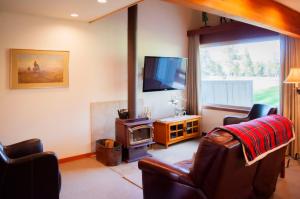a living room with a tv and a couch and a chair at Golf Condo 098 in Black Butte Ranch