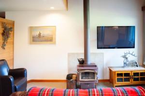 a living room with a wood stove and a tv at Golf Condo 098 in Black Butte Ranch