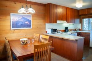 a kitchen with a table and chairs and a kitchen with a mountain at Golf Condo 098 in Black Butte Ranch