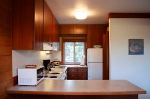 a kitchen with wooden cabinets and a white microwave at Golf Condo 098 in Black Butte Ranch +17 photos