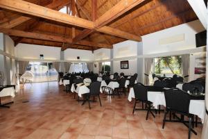 a banquet hall with tables and chairs and wooden ceilings at Dalby Manor Motor Inn in Dalby