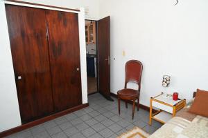 a living room with a wooden door and a chair at Como en casa in Rawson