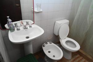 a bathroom with a white toilet and a sink at Como en casa in Rawson