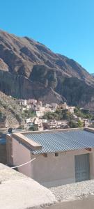 a building with solar panels on the side of a mountain at Alojamiento Lidia in Iruya