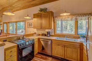 a kitchen with wooden cabinets and a stove and a sink at East Meadow 017 in Black Butte Ranch